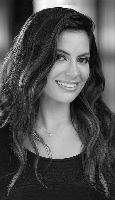 Woman smiling with long, wavy hair.