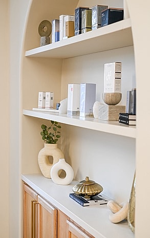 Elegant shelves with skincare products and decor.