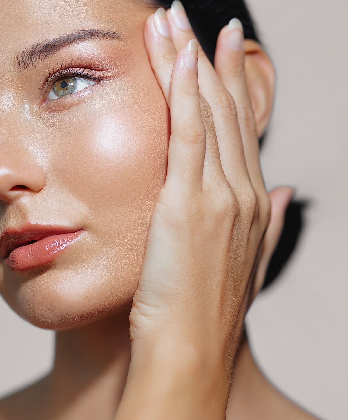 Close-up of a woman touching her face.
