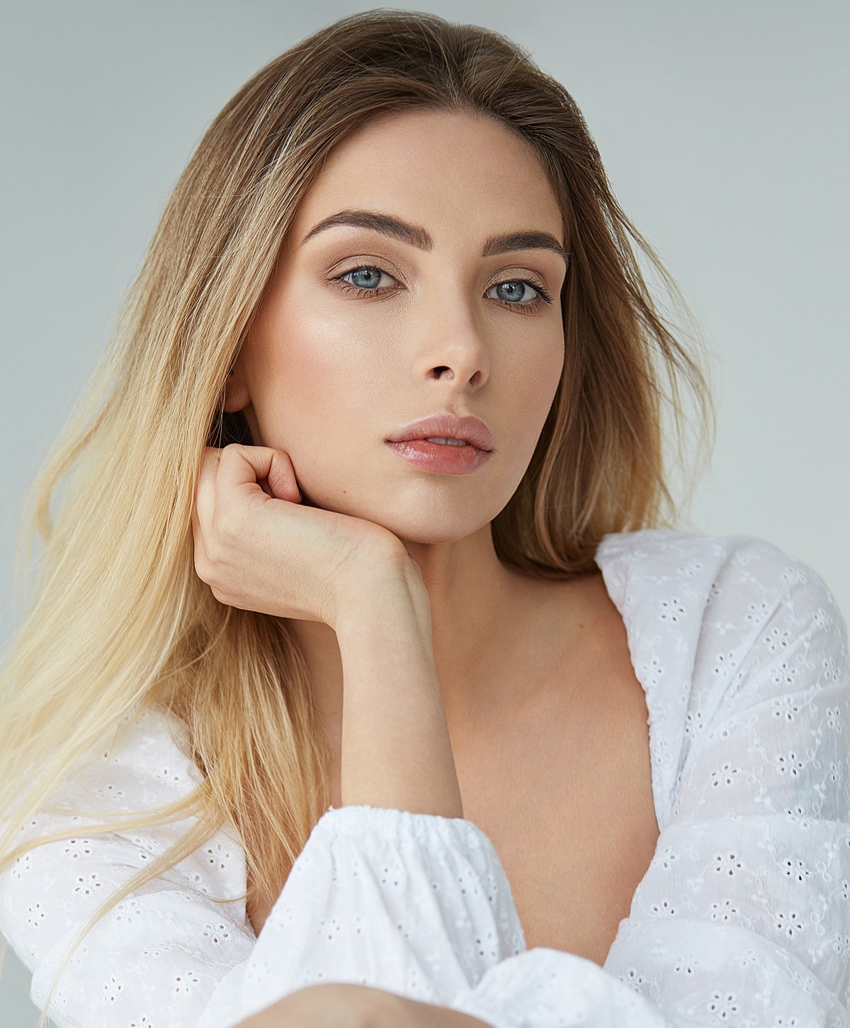 Woman with long hair and thoughtful expression.
