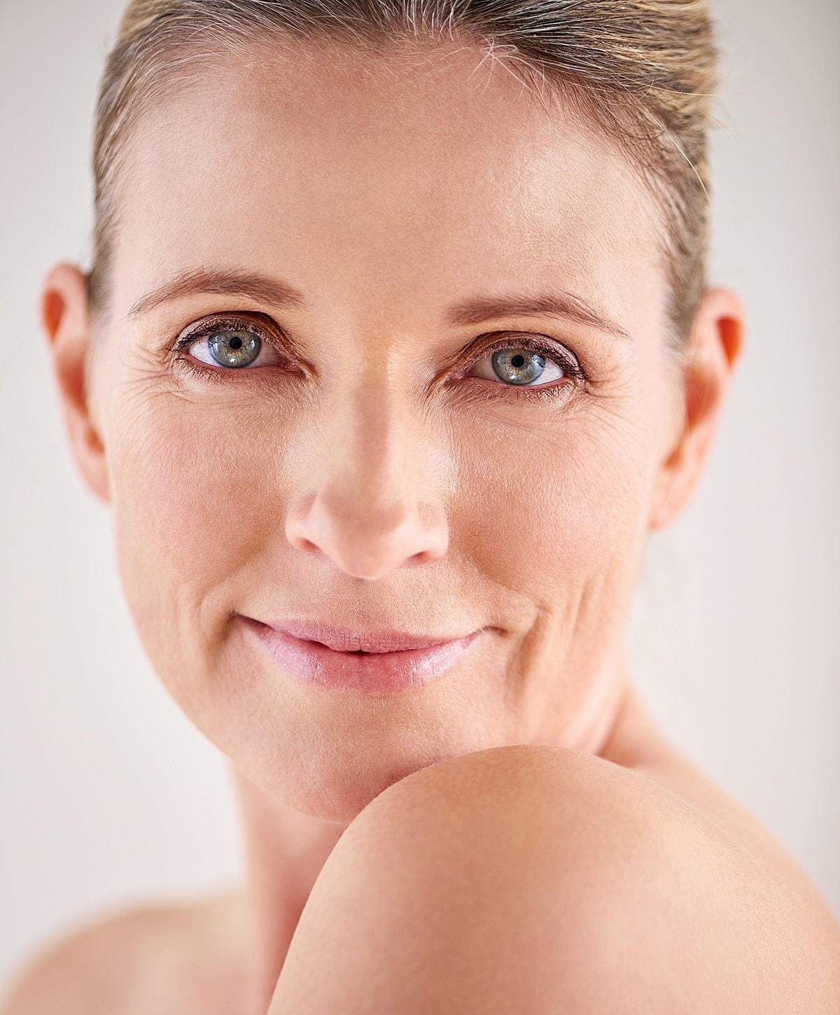 Smiling woman with natural makeup and clear skin.