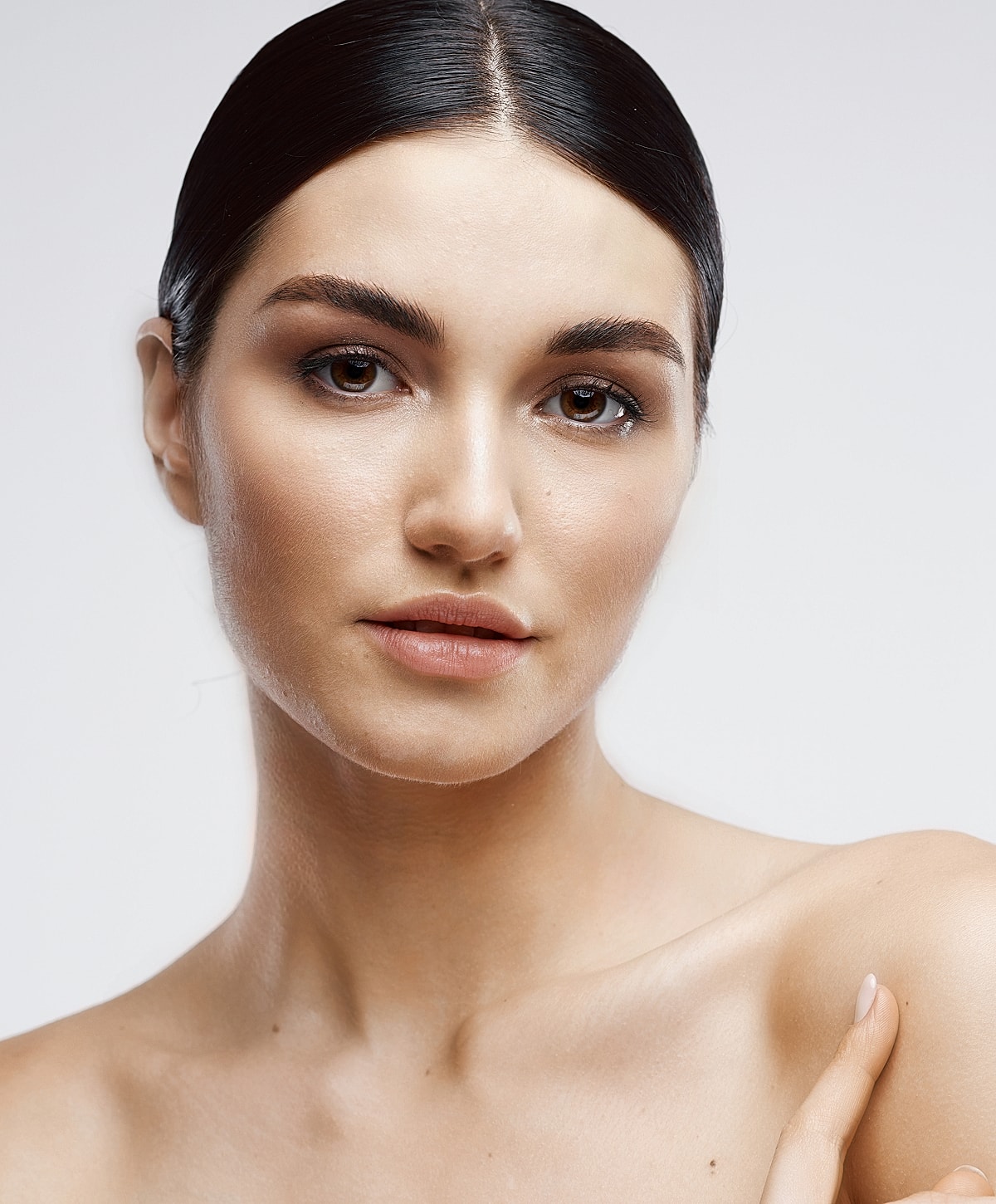 Model with natural makeup and sleek hairstyle.