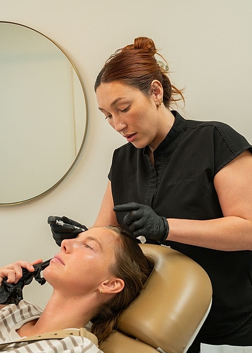 Beauty technician performing treatment on client.