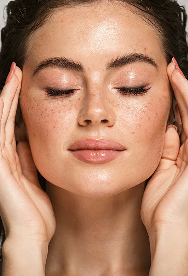 Woman with freckled face relaxing and self-caring.