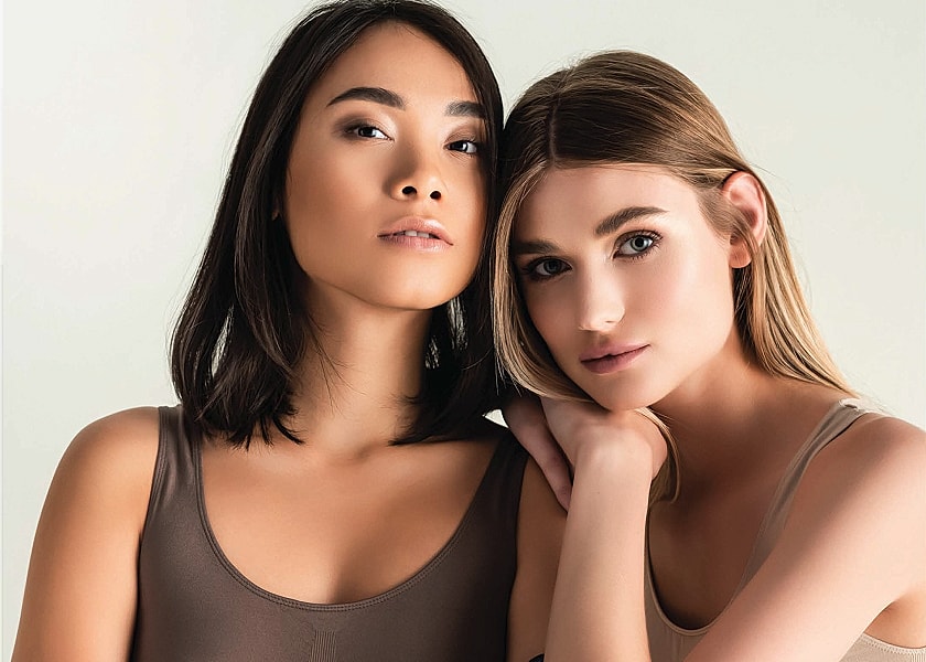 Two women in skin-toned clothing, close together.