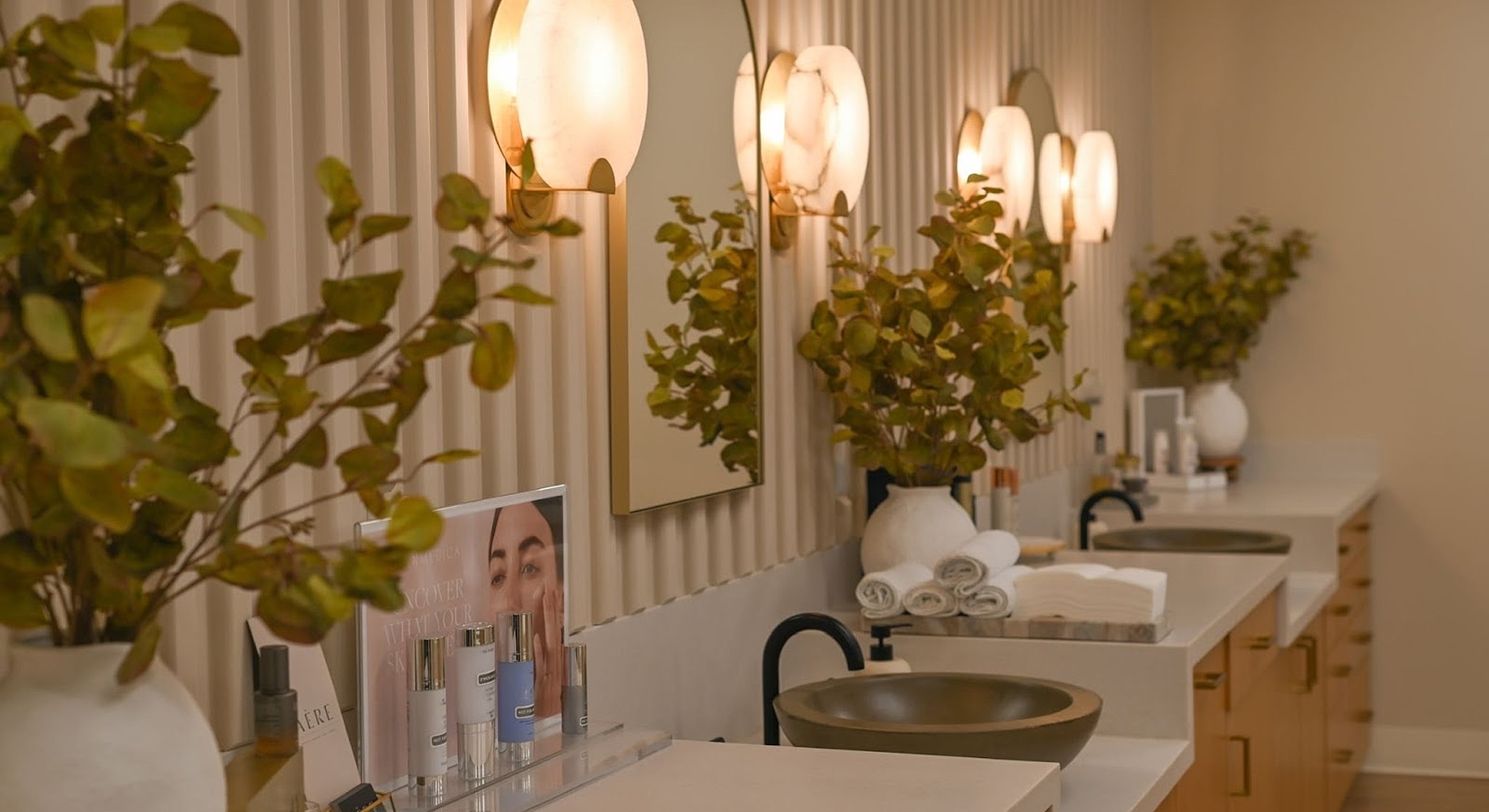 Modern skincare vanity with plants and mirrors.