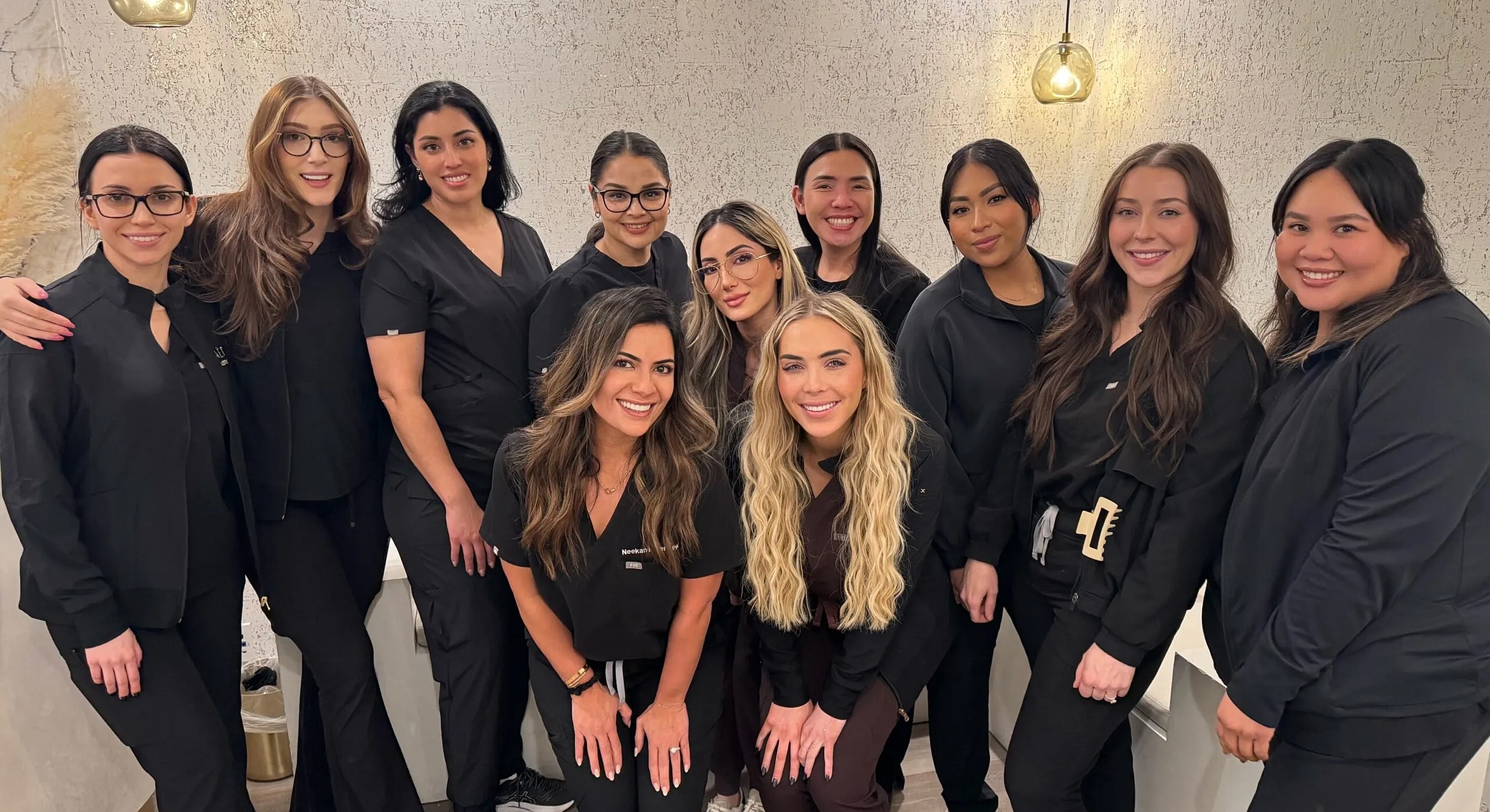 Professionals posing together in black attire.