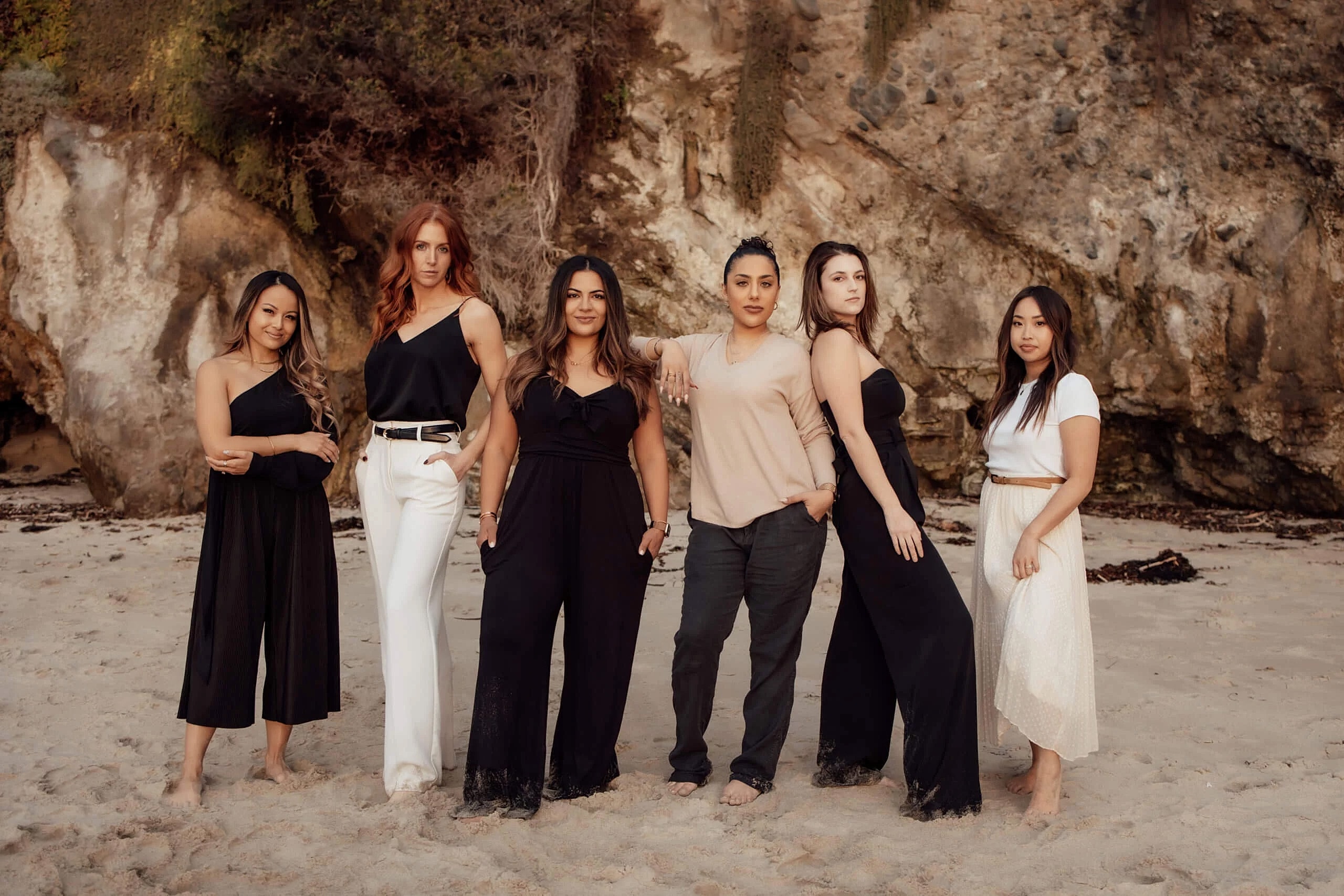 Group of women posing on the beach.