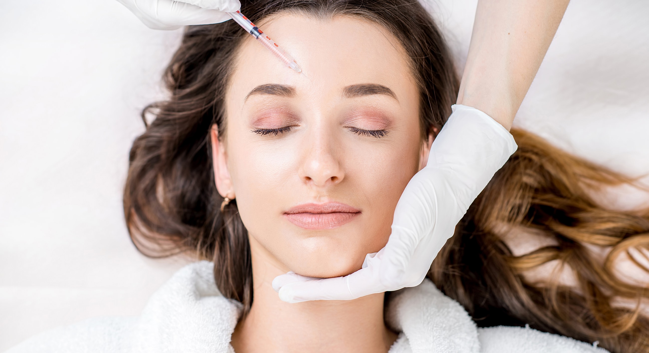 Woman receiving cosmetic treatment on her forehead.