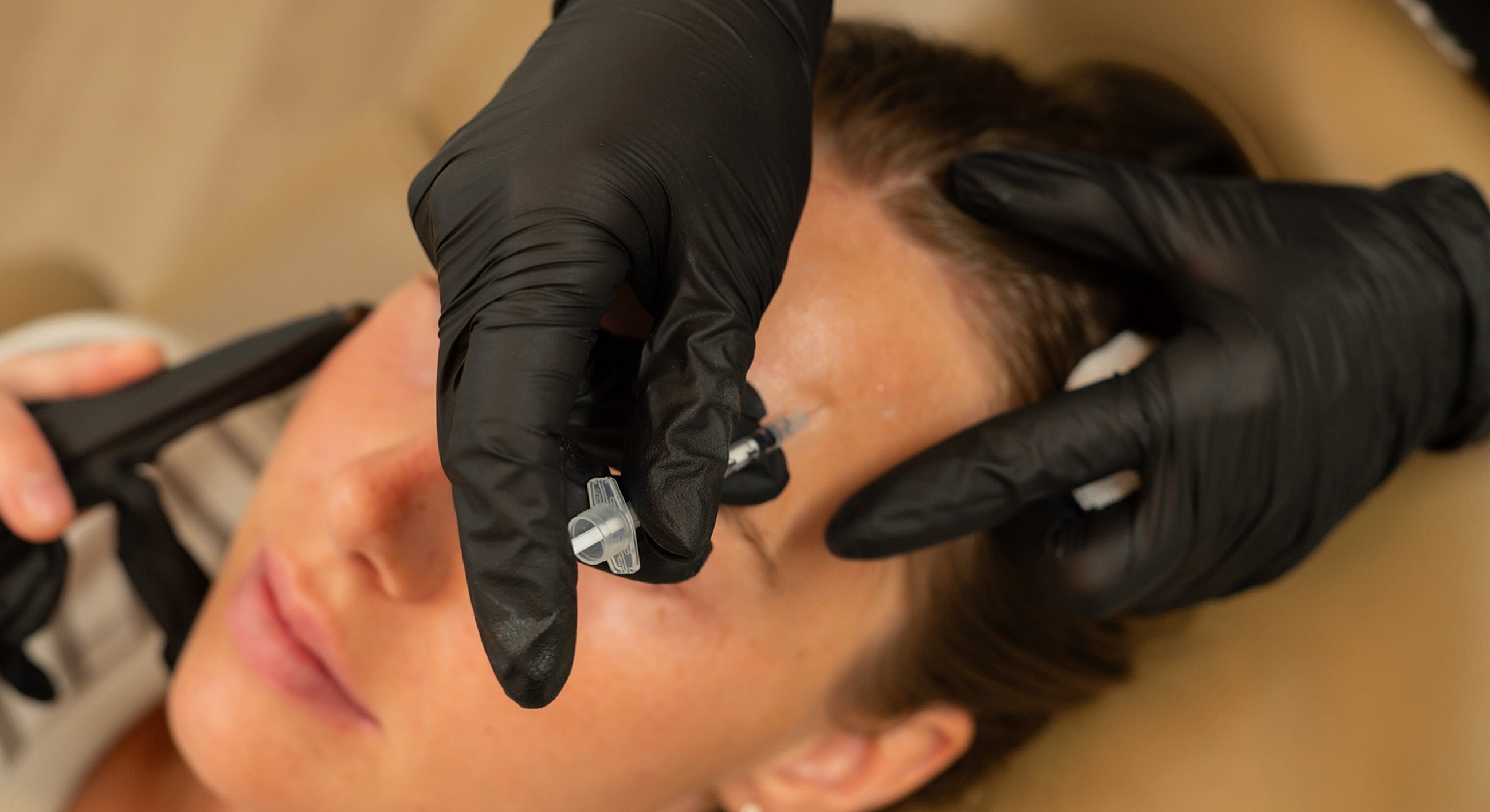 Injection procedure on a woman's forehead.