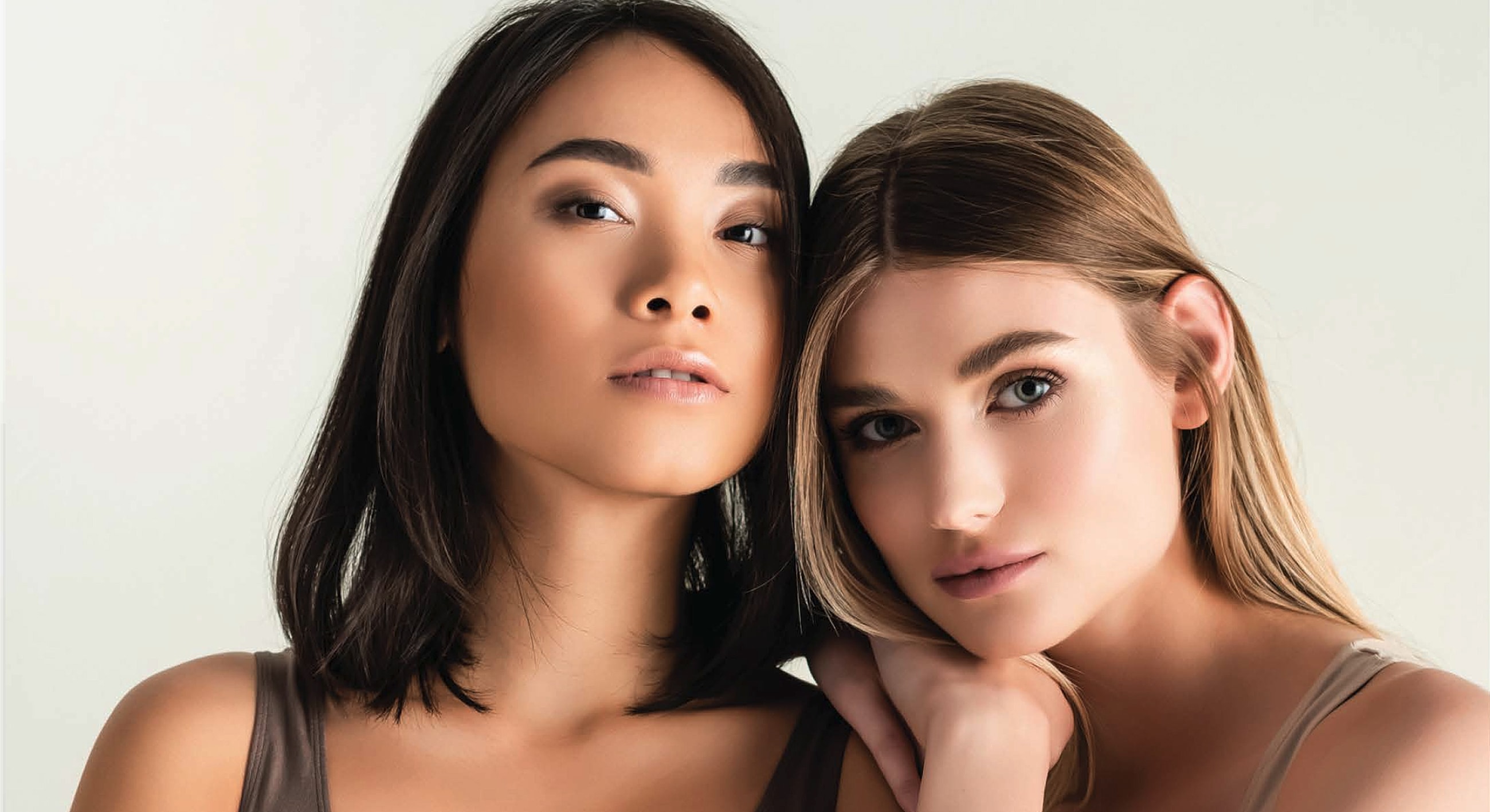 Two women posing closely together, elegant portrait.