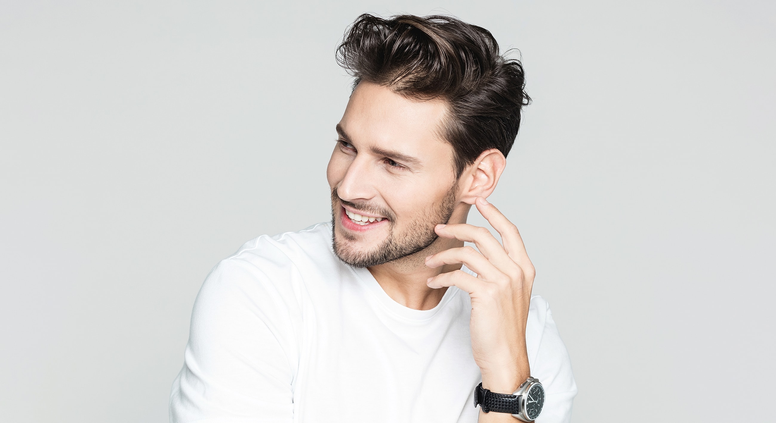 Smiling man in white shirt, stylish hair.