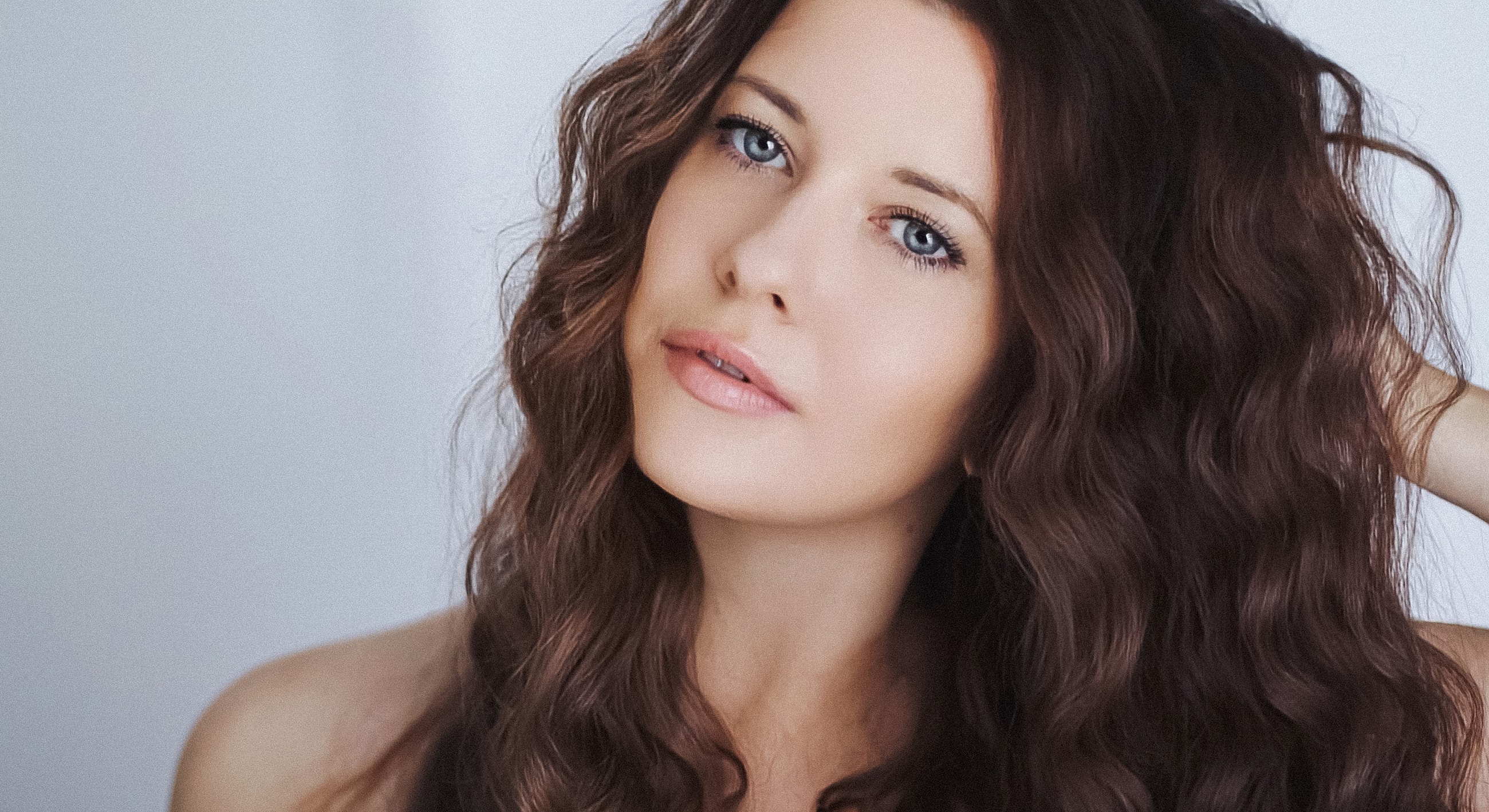 Woman with wavy hair and captivating blue eyes.