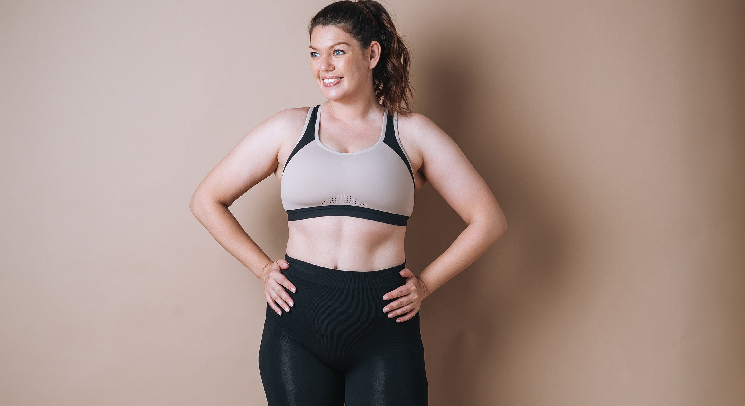 Athletic woman in activewear, smiling confidently.