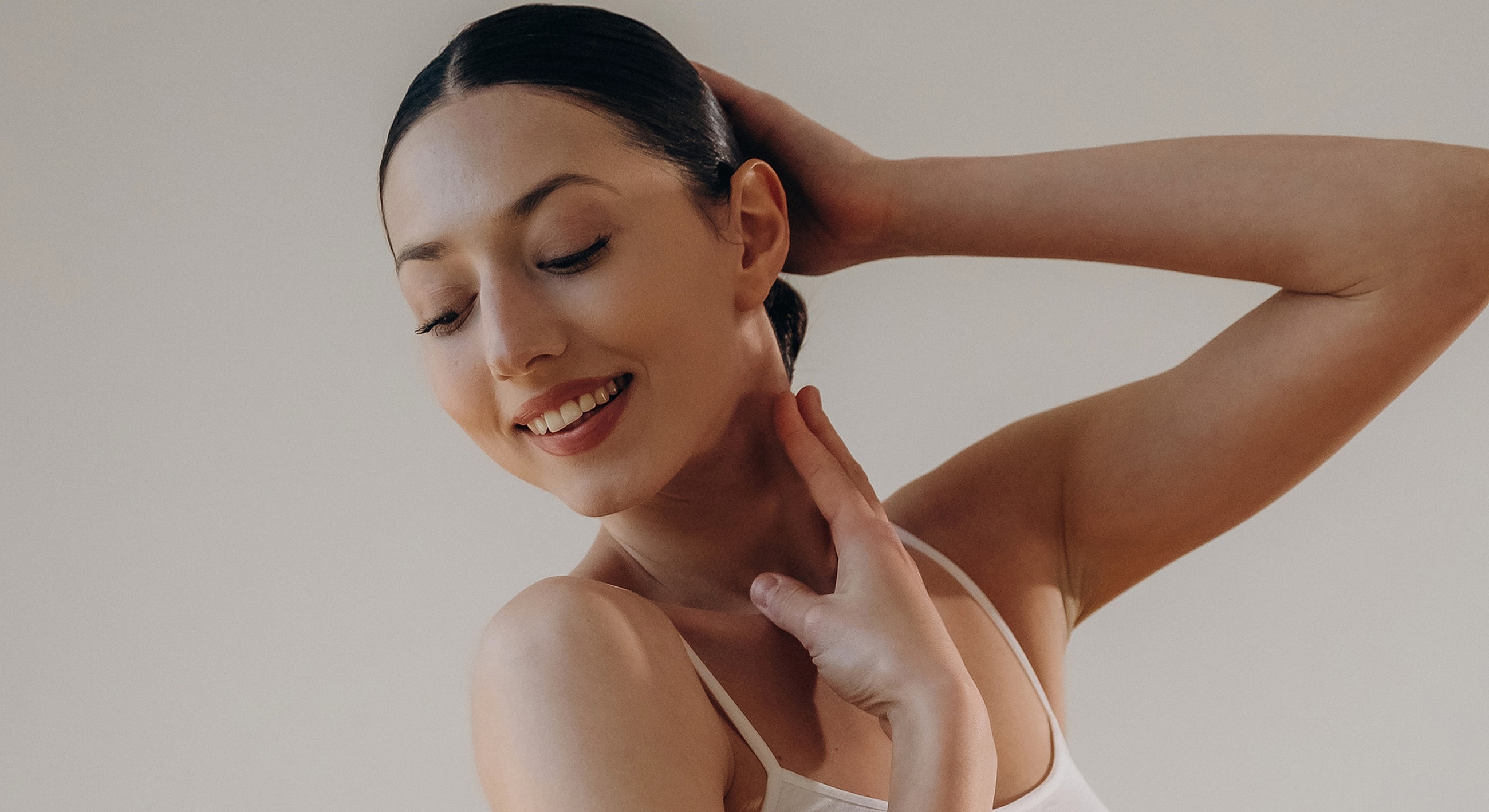 Smiling woman with graceful pose and soft lighting.
